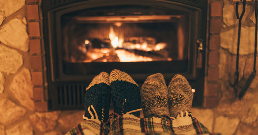 Feet kicked up by a wood stove in a warm setting